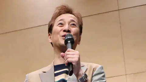 Getty Images Masahiro Nakai pictured with a mic at an event