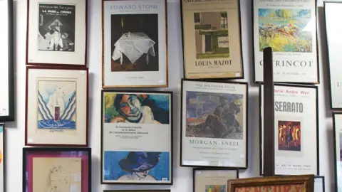 PA Media A selection of French art posters hanging on a wall. 