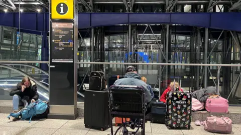 PA Media People sitting and waiting in Terminal Five