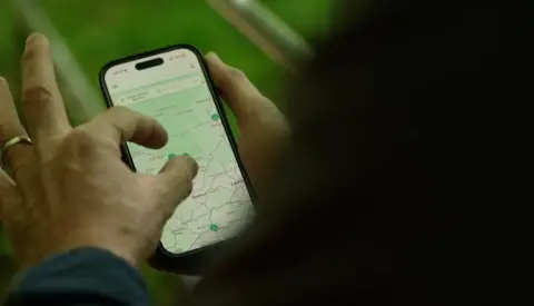A man pinches a screenshot of a map on his phone