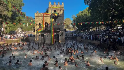 BBC/Amensisa Negera Attendees get baptised in a huge outdoor pool