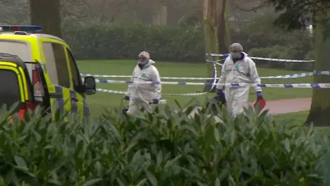 Two forensic officers inside the police cordon