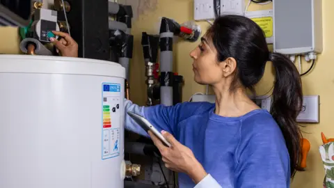 Woman adjusts thermostat