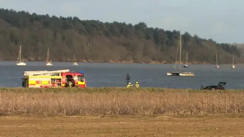Martin Giles/BBC Emergency services rescue flooded cars from The Strand near Orwell Bridge