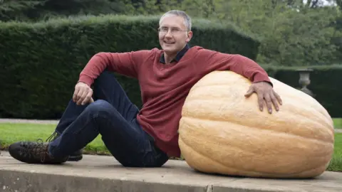 PA Media Chris Parish with his winning 102kg giant pumpkin