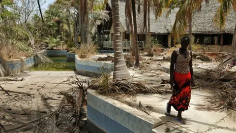 AFP A Senegalese woman walks near an abandoned hotel