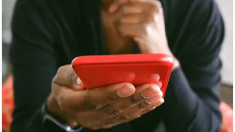 Getty Images Hand holding phone