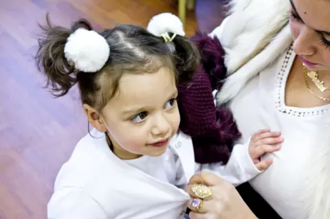 Laura Balogova young child in white outfit