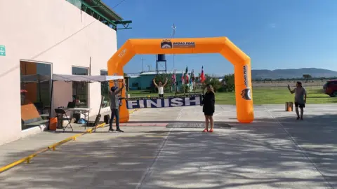 Stuart Gillett Mr Gillett finishing the Deca Ironman, running through an inflatable arch.