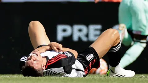 Fulham midfielder Joao Palhinha lies injured on the field