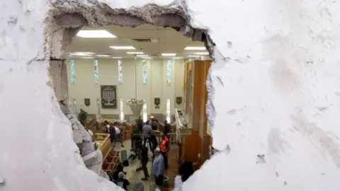 Reuters People clean inside a synagogue damaged by a rocket, as Israeli-Palestinian cross-border violence continues, in Ashkelon, southern Israel May 16, 2021