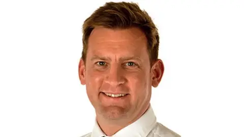 University Hospitals of Leicester NHS Trust Smiling man with medium-length brown hair