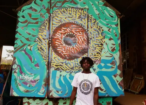 BBC Man standing in front of train with graffiti