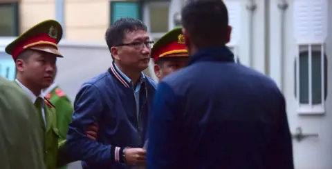 Getty Images Trinh Xuan Thanh led into court in Hanoi (9 Jan 2018)