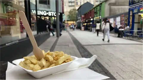 a container of chips at the entrance to Cardiff's Caroline Street