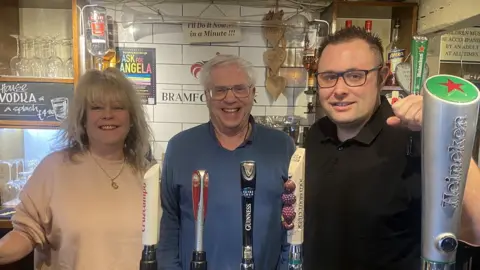 Wayne Bavin/BBC Landlady Teresa Brinkley, with David and landlord Luke Mohammad