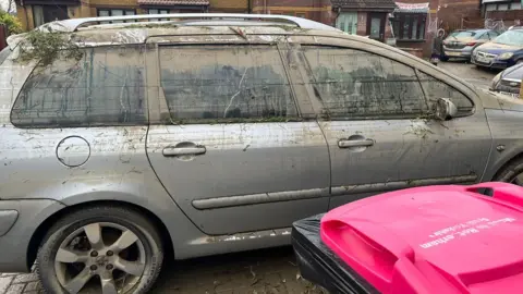 Sally Breeze A car covered in mud