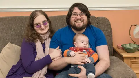 Carers Wales Edward Grace, pictured with his wife and their one-year old son