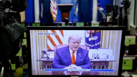 Getty Images A television monitor in the White House Press Briefing Room displays a recorded address by former President Donald Trump