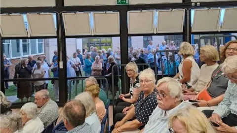 David Kennedy Hundreds of people gathered in a school auditorium and others had to stand outside during the meeting