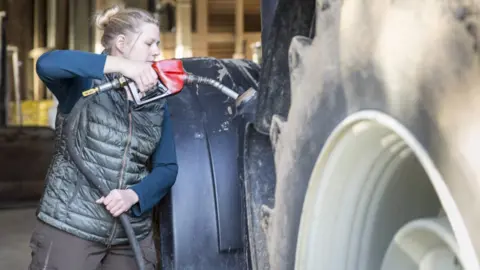 Getty Images Farmer refuels tractor