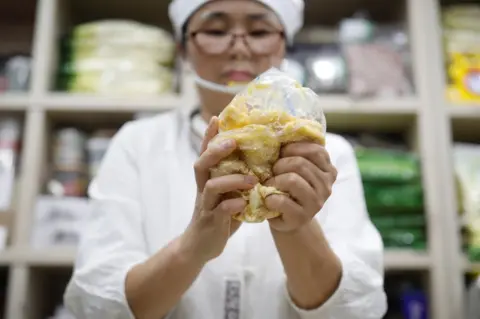 Reuters North Korean defector Hong Eun-hye demonstrates how North Korean people make rice cakes with corn powder at her North Korean food store in Seoul, South Korea, 28 September 2017.