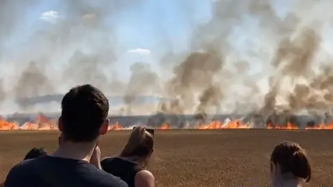 @ulxeus Locals watch on as the fire spreads cross a field