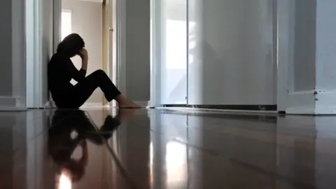 Getty Images Woman sitting in her bedroom