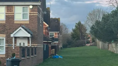 LDRS Rubbish seen on walking path next to a house.