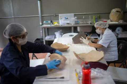 AFP Researchers clean artefacts found amid the debris