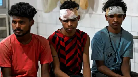 Getty Images Three young men who survived the crash in hospital, two with bandages around their heads
