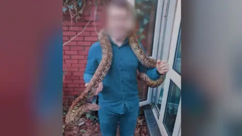 Missing snake around man's shoulders