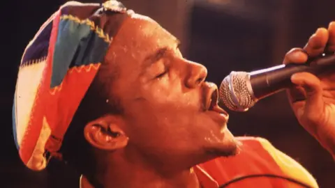 Getty Images Andrew Tosh singing in reggae hat