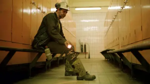 Alamy David Hunter in his miner's clothing sitting on a bench