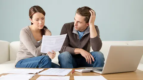 Getty Images Couple looking worried about bills