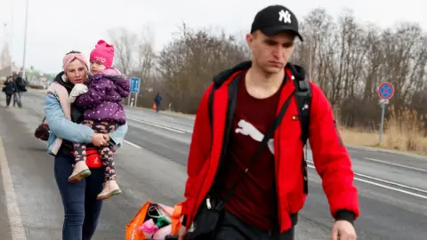 Reuters People flee from Ukraine at the Hungarian-Ukrainian border