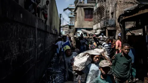 Getty Images Residents trying to salvage their belonging from a fire that ravaged overnight a section of the Anosibe central market in Antananarivo.