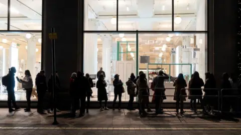 Getty Images People queue in the dark