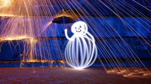 Kevin Jay/Micheal Simmans Snowman light painting with wire wool sparks on Frinton beach in Essex