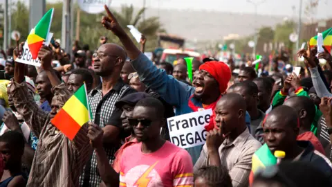 AFP A man in a crowd shouts as he holds a sign that reads, "France get out" during a protest against French and UN forces based in Mali - Bamako, 10 January 2020