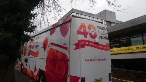 A bus tour is taking the station around Wales