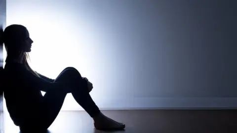 Getty Images Teenager sitting alone in dark room