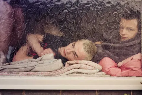 Sarah Lee Joe and Duke Brooks, behind a window pane