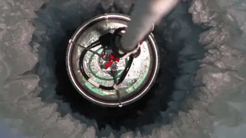 Mark Krasberg/IceCube/NSF One of the individual neutrino detectors - suspended in the ice on a cable