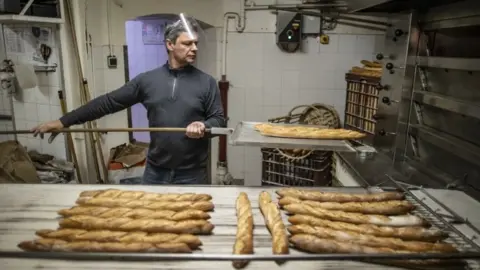 EPA A baker makes baguettes in France