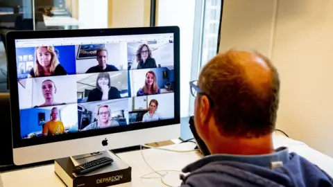 Getty Images A man looks at a Zoom call on his computer