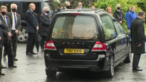 Mourners stood outside in the rain as John Hume's coffin was taken away to the city cemetery