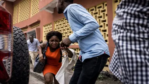 AFP/Getty A woman runs for cover in Kinshasa