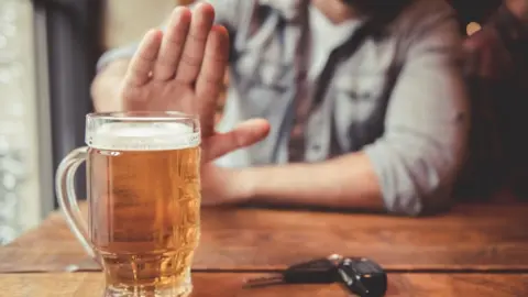 Getty Images Man with drink and car keys