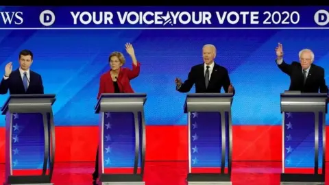 Reuters From left to right: Pete Buttigieg, Elizabeth Warren, Joe Biden and Bernie Sanders take part in the debate in Manchester, New Hampshire. Photo: 7 February 2020